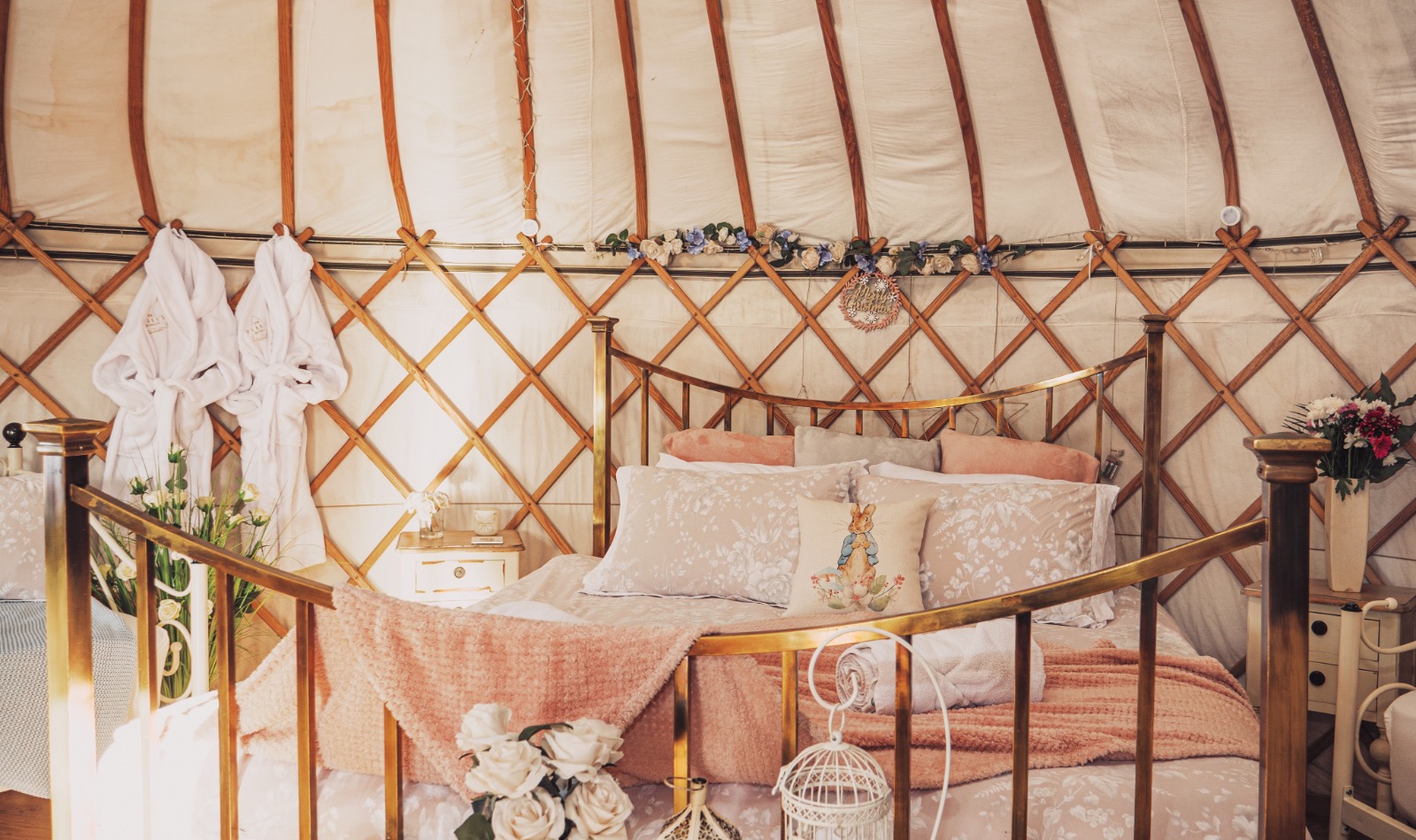 shabby chic luxury glamping yurt interior, in pink and whites with supering size bed